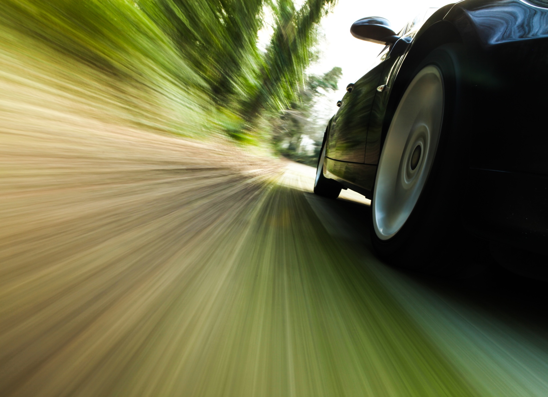 Front,Side,View,Of,Black,Car,Driving,Fast.